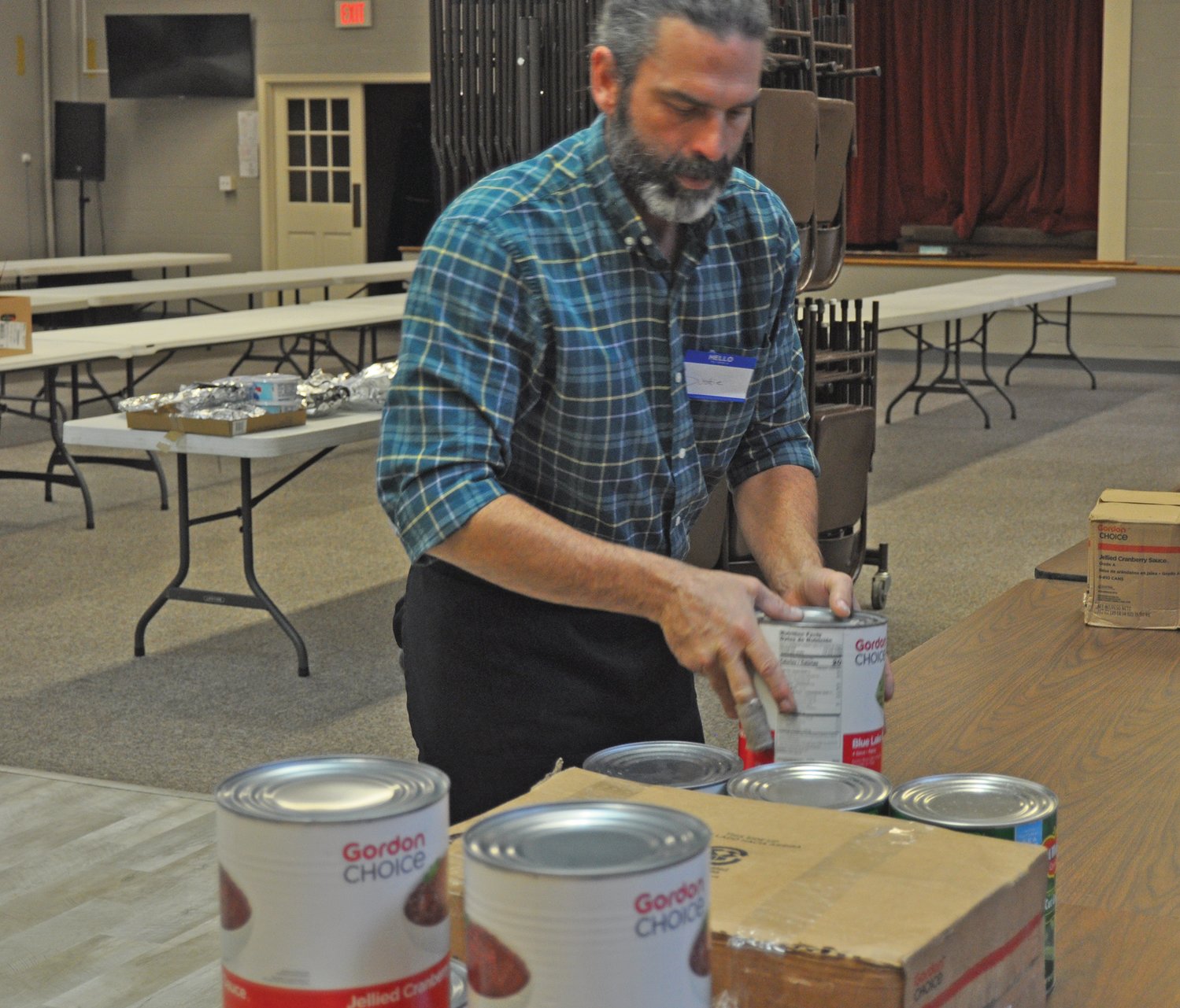 Dustie Meadows unpacks cans of cranberry sauce Wednesday during preparations for the Community Thanksgiving Dinner at First United Methodist Church.